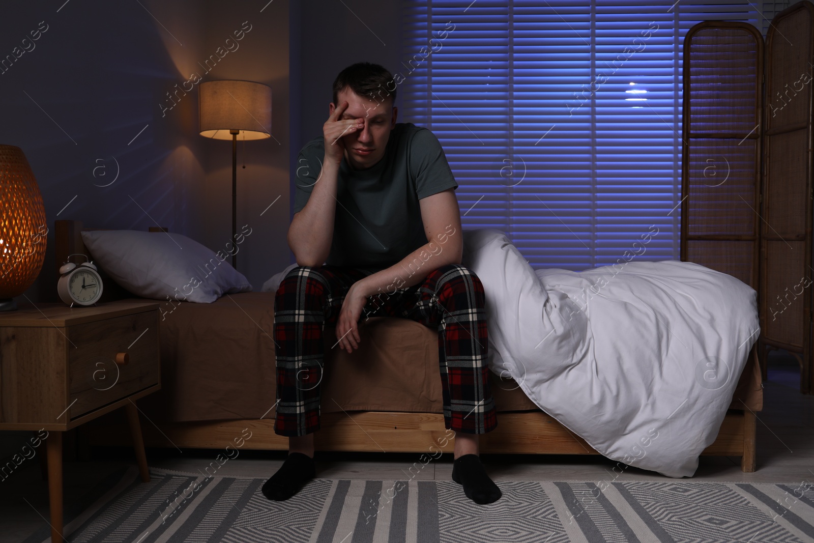 Photo of Frustrated man suffering from insomnia on bed indoors