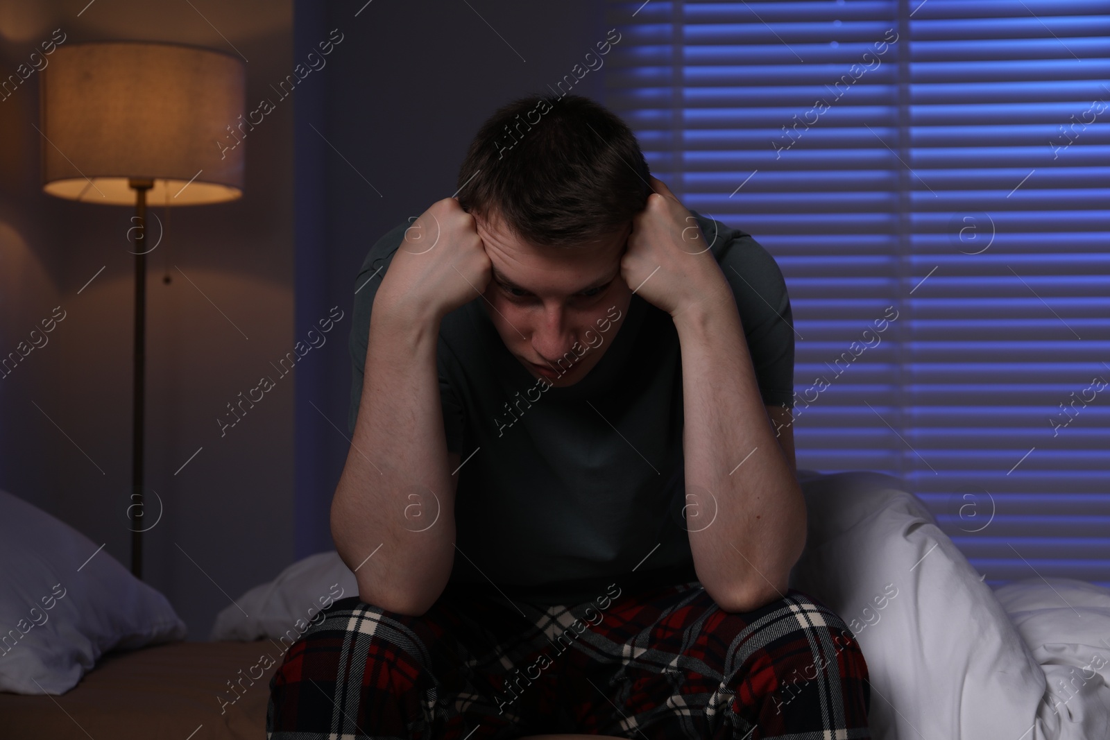 Photo of Frustrated man suffering from insomnia on bed indoors