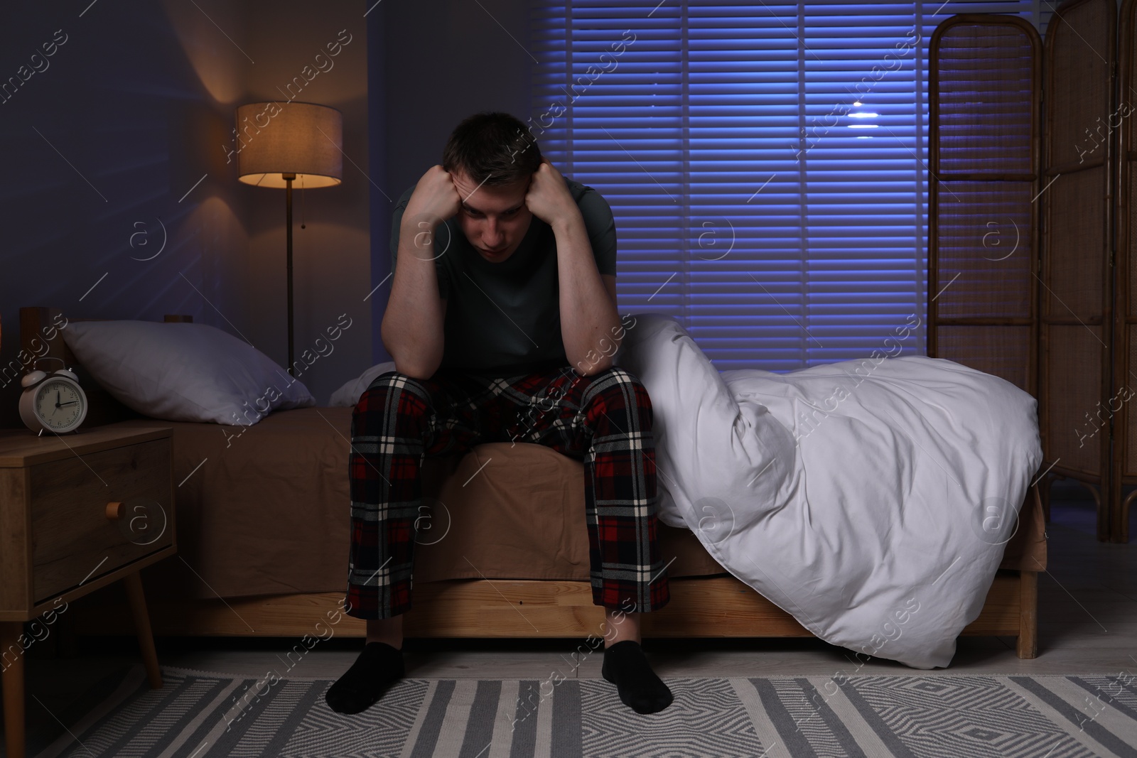 Frustrated man suffering from insomnia on bed indoors Photo of Frustrated man suffering from insomnia on bed indoors