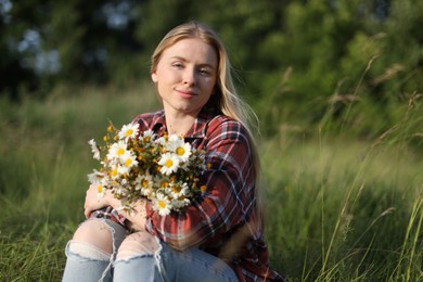 Photo of Beautiful woman with wildflowers enjoying summer day in meadow. Space for text