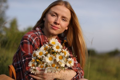 Photo of Beautiful woman with wildflowers enjoying summer day in meadow
