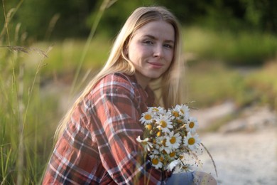 Photo of Beautiful woman with bouquet of wildflowers in meadow