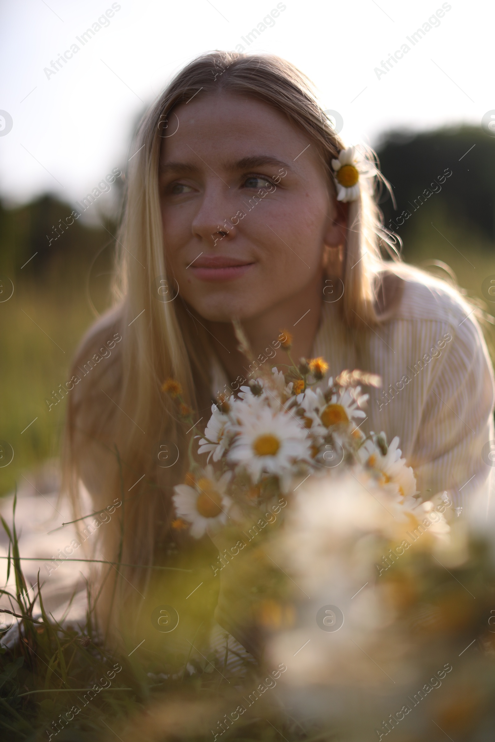 Beautiful woman with wildflowers in meadow on sunny day Photo of Beautiful woman with wildflowers in meadow on sunny day