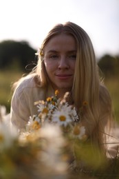 Photo of Beautiful woman with wildflowers in meadow on sunny day