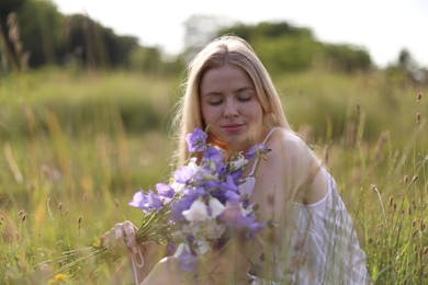 Photo of Beautiful woman with bouquet of wildflowers enjoying sunny day in meadow