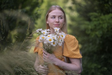 Photo of Beautiful woman with bouquet of wildflowers in forest