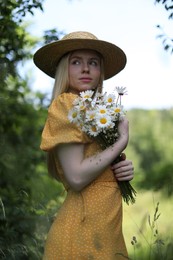 Photo of Beautiful woman with bouquet of wildflowers in forest