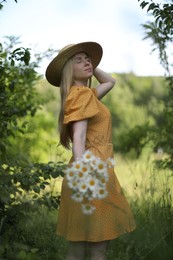 Photo of Beautiful woman with bouquet of wildflowers in forest