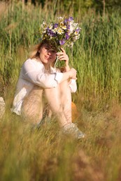 Photo of Woman with bouquet of beautiful wildflowers outdoors on sunny day
