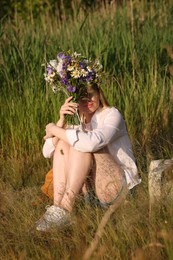 Photo of Woman with bouquet of beautiful wildflowers outdoors on sunny day