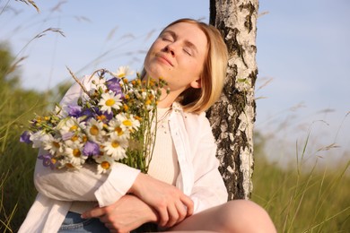 Photo of Woman with bouquet of beautiful wildflowers outdoors on sunny day