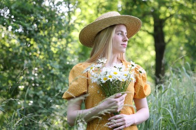 Photo of Beautiful woman with bouquet of wildflowers in forest