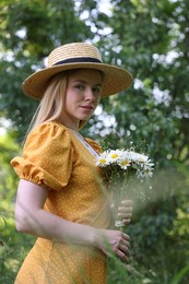 Photo of Beautiful woman with bouquet of wildflowers in forest