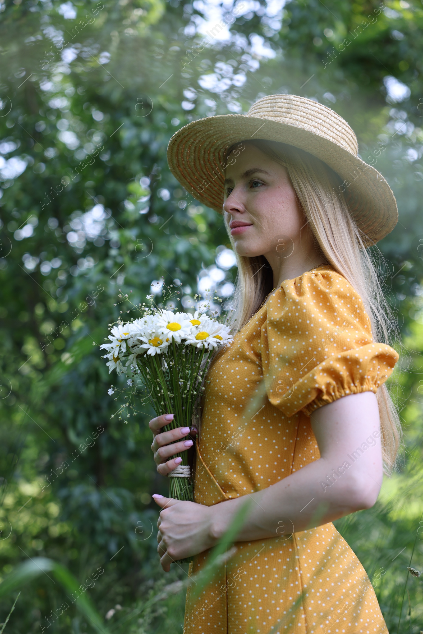 Beautiful woman with bouquet of wildflowers in forest Photo of Beautiful woman with bouquet of wildflowers in forest