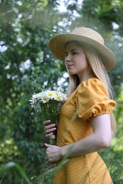 Photo of Beautiful woman with bouquet of wildflowers in forest