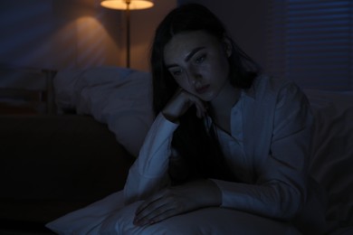 Photo of Frustrated woman with pillow suffering from insomnia on floor at home, space for text
