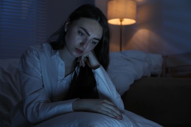 Photo of Frustrated woman with pillow suffering from insomnia on floor at home, space for text