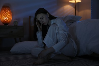 Photo of Frustrated woman suffering from insomnia on floor at home