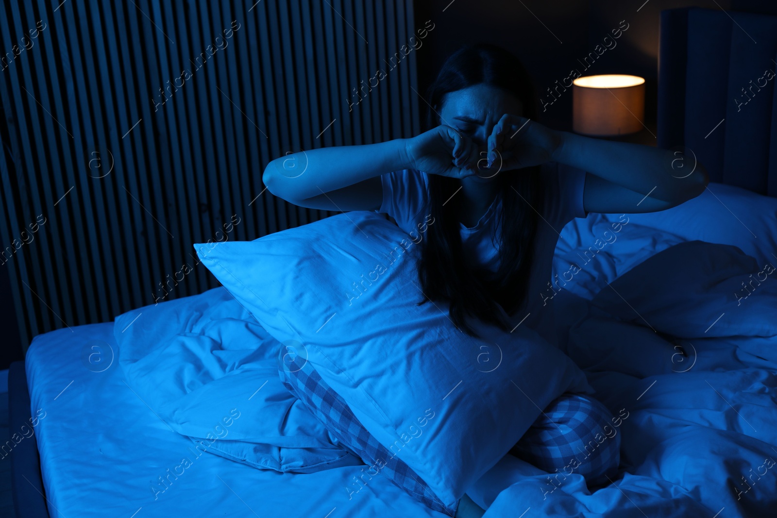 Frustrated woman with pillow suffering from insomnia on bed at home Photo of Frustrated woman with pillow suffering from insomnia on bed at home