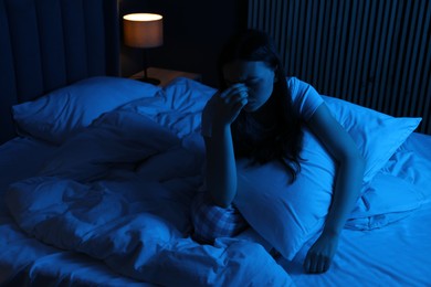 Photo of Frustrated woman with pillow suffering from insomnia on bed at home