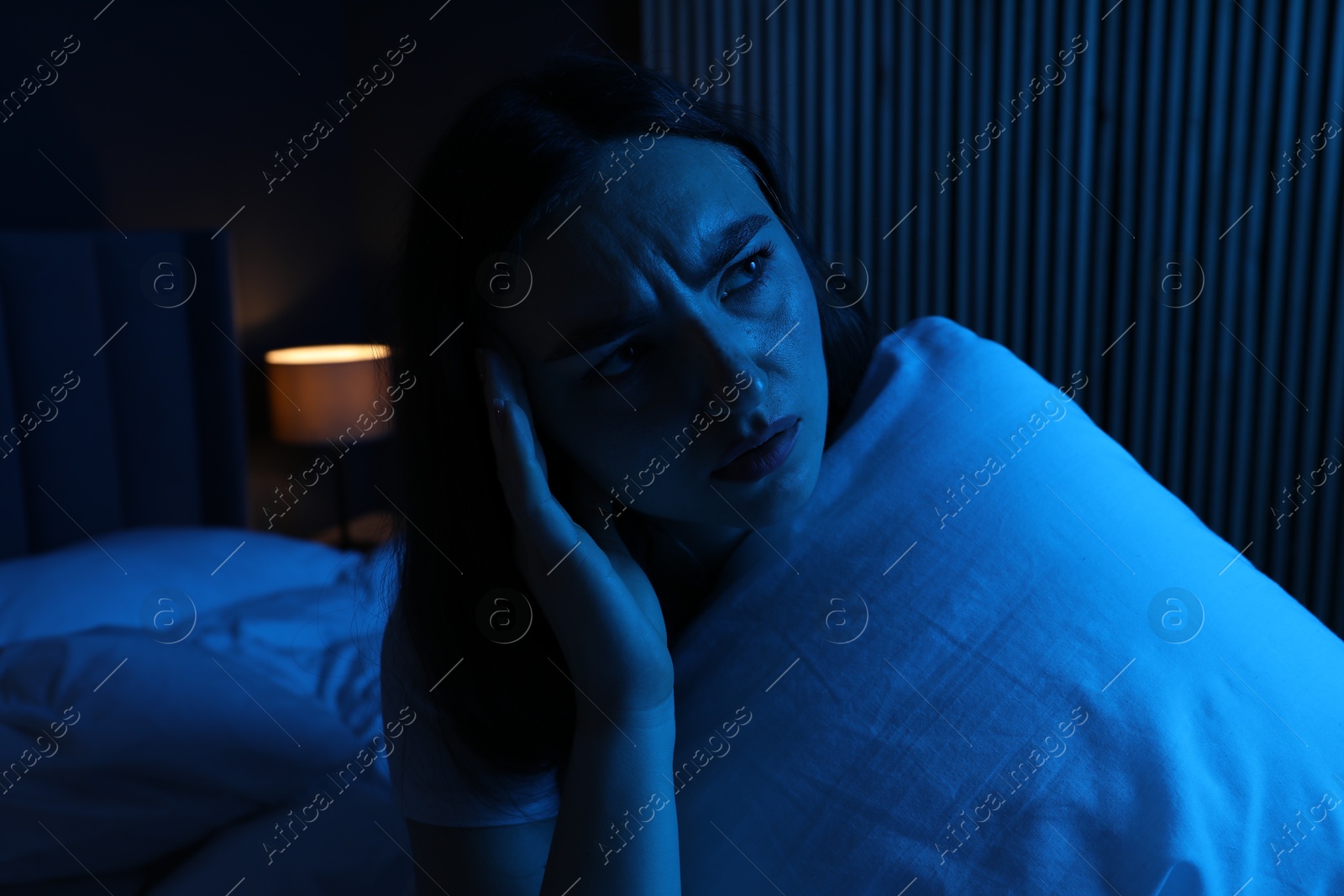 Frustrated woman with pillow suffering from insomnia on bed at home Photo of Frustrated woman with pillow suffering from insomnia on bed at home