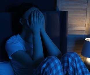 Photo of Frustrated woman suffering from insomnia on bed at home