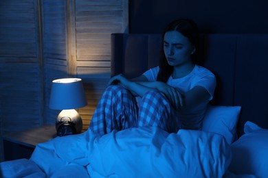 Photo of Frustrated woman suffering from insomnia on bed at home