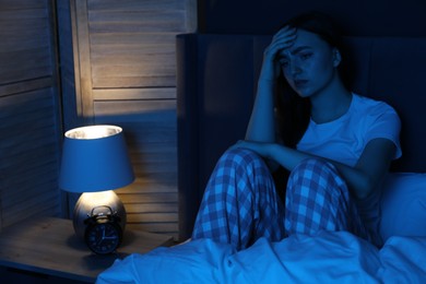 Photo of Frustrated woman suffering from insomnia on bed at home