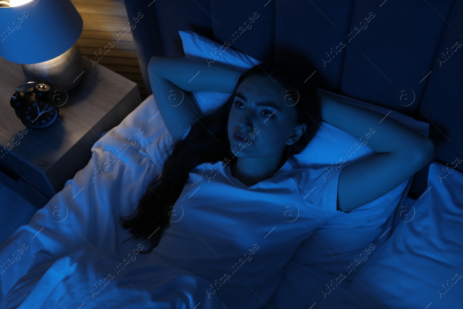 Frustrated woman suffering from insomnia in bed at home, above view Photo of Frustrated woman suffering from insomnia in bed at home, above view