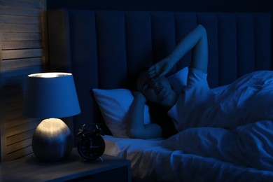 Photo of Frustrated woman suffering from insomnia in bed at home