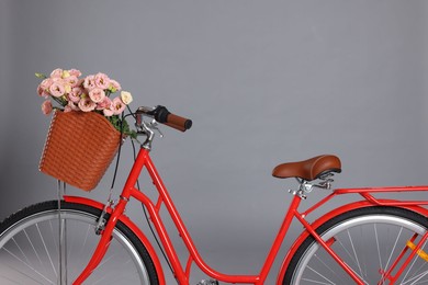 Photo of Bicycle with basket of beautiful flowers on grey background