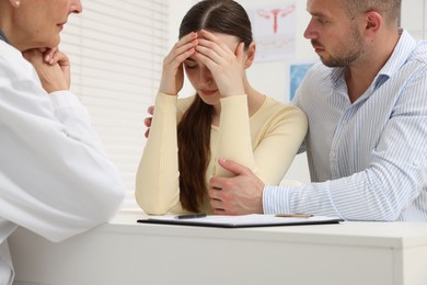 Photo of In vitro fertilization (IVF). Upset couple having consultation with doctor in reproductive clinic, closeup