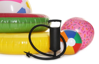 Photo of Inflatable rings, balls and manual air pump isolated on white