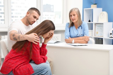 Photo of In vitro fertilization (IVF). Upset couple having consultation with doctor in reproductive clinic