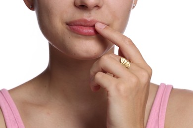 Photo of Young woman with lip balm on her lips against white background, closeup