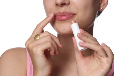 Photo of Young woman with lip balm on white background, closeup