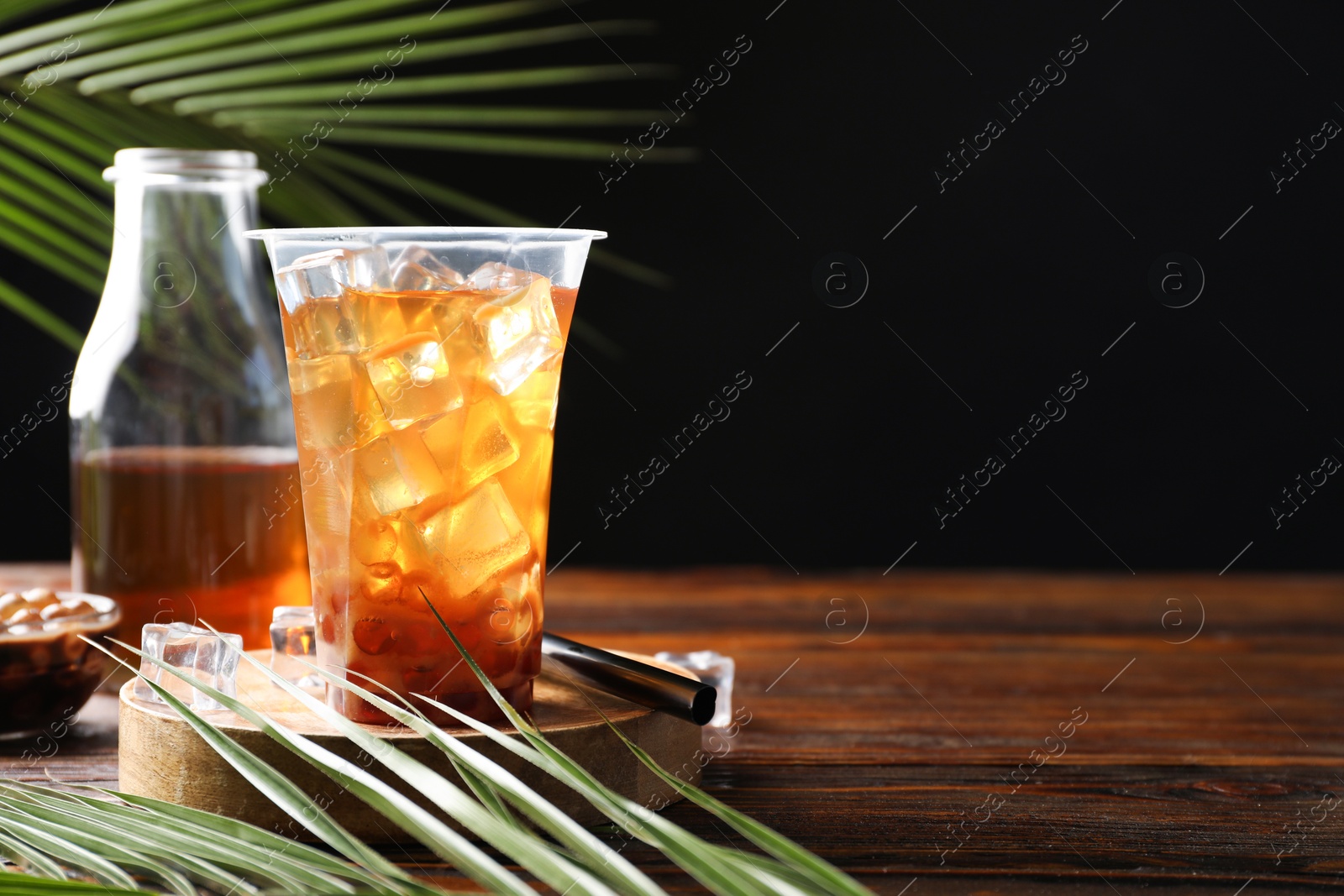 Tasty iced bubble tea and ingredients on wooden table. Space for text Photo of Tasty iced bubble tea and ingredients on wooden table. Space for text