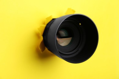 Photo of Hidden camera lens through hole in yellow paper, closeup
