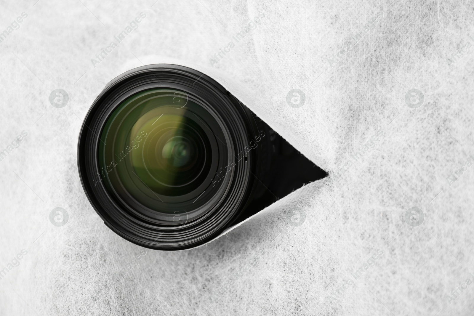 Hidden camera lens through torn hole in white fabric Photo of Hidden camera lens through torn hole in white fabric