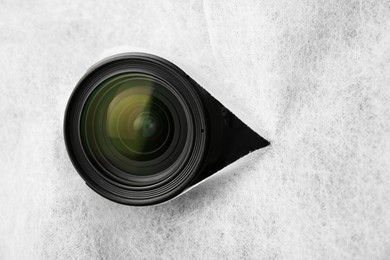 Photo of Hidden camera lens through torn hole in white fabric