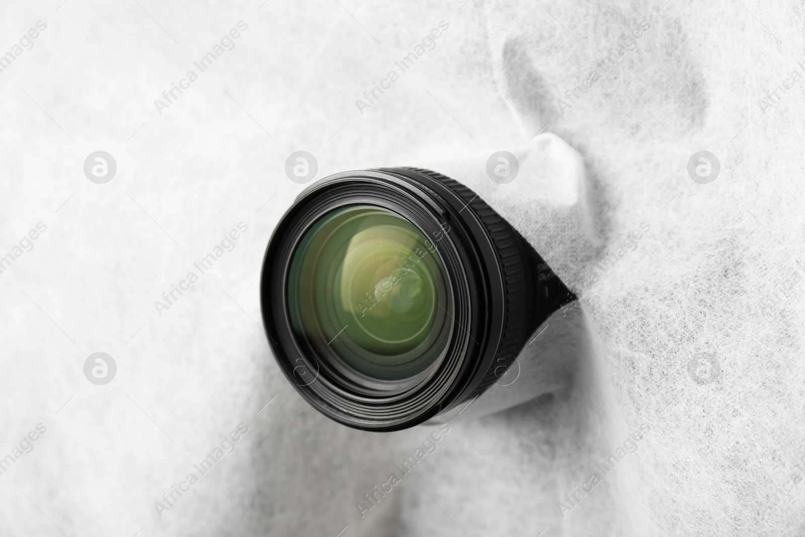Photo of Hidden camera lens through torn hole in white fabric