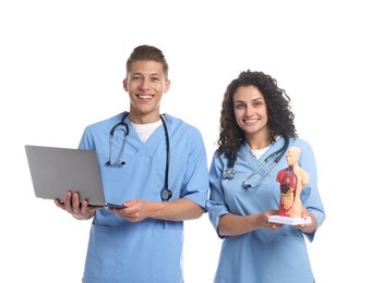 Photo of Medical students with laptop and human body model on white background