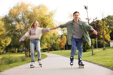 Photo of Happy couple roller skating together in park