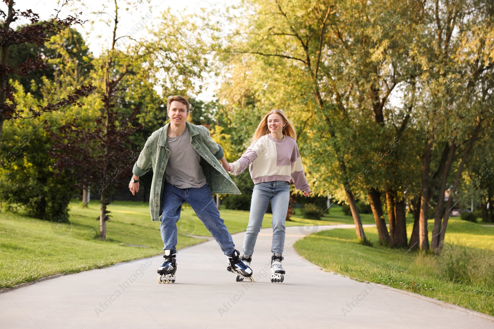Happy couple roller skating together in park Photo of Happy couple roller skating together in park