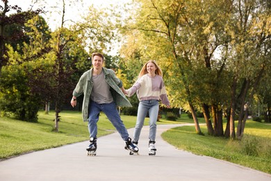 Photo of Happy couple roller skating together in park
