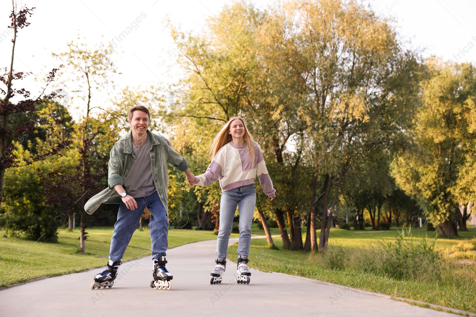Happy couple roller skating together in park Photo of Happy couple roller skating together in park