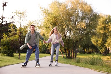 Photo of Happy couple roller skating together in park
