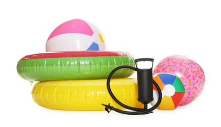 Photo of Inflatable rings, balls and manual air pump isolated on white