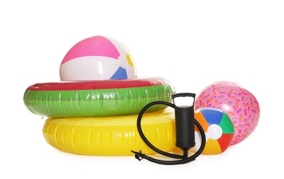 Photo of Inflatable rings, balls and manual air pump isolated on white