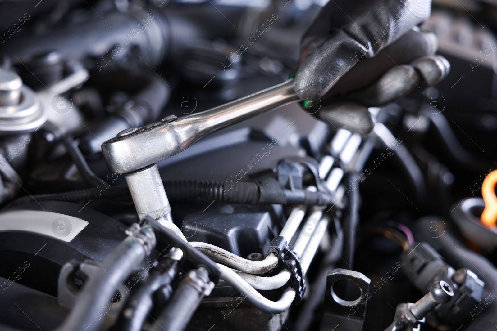 Auto parts. Professional mechanic with torque wrench fixing car indoors, closeup Photo of Auto parts. Professional mechanic with torque wrench fixing car indoors, closeup
